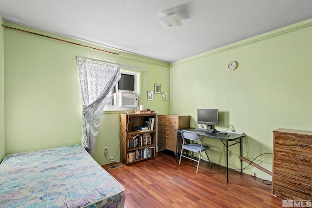 bedroom featuring cooling unit and wood finished floors