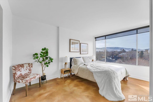 bedroom featuring light colored carpet, baseboards, and a mountain view