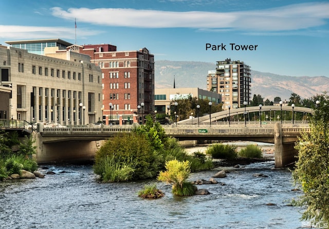 property's view of city with a water and mountain view