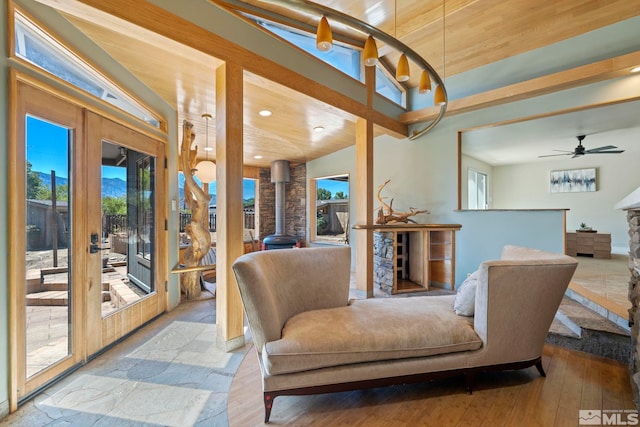 living room with wood ceiling, light hardwood / wood-style flooring, ceiling fan, and a healthy amount of sunlight