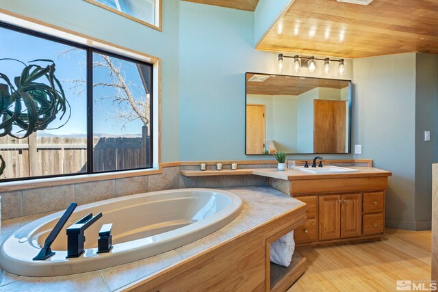 bathroom featuring tiled tub, vanity, wood ceiling, and wood-type flooring