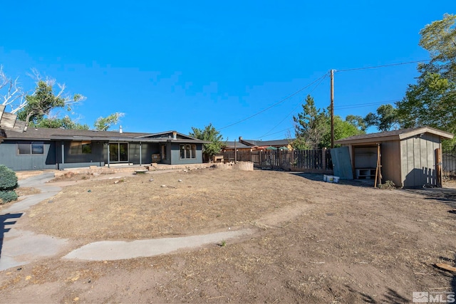 view of yard featuring an outbuilding, a shed, and fence