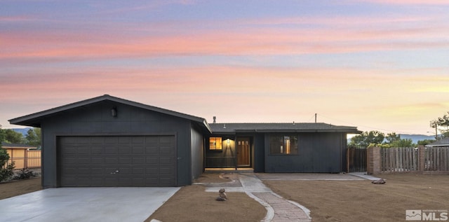 view of front of house with a garage, driveway, and fence