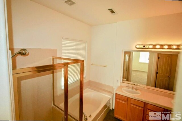 bathroom featuring a washtub and vanity