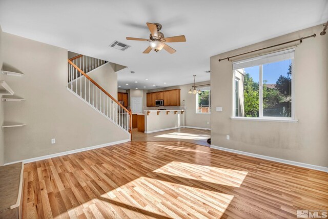 unfurnished living room featuring ceiling fan and light hardwood / wood-style floors