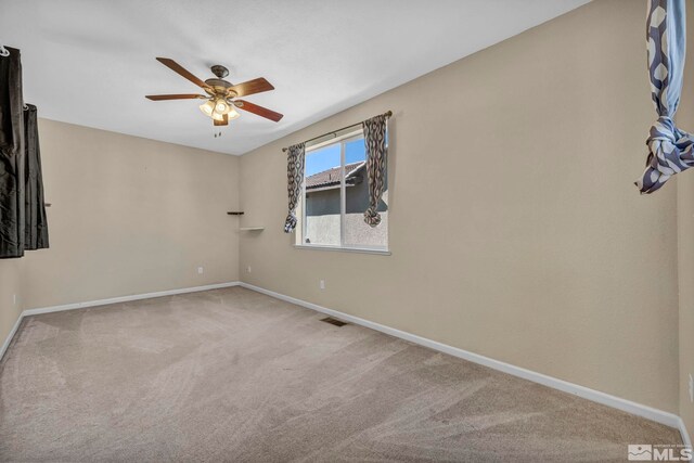 carpeted spare room featuring ceiling fan