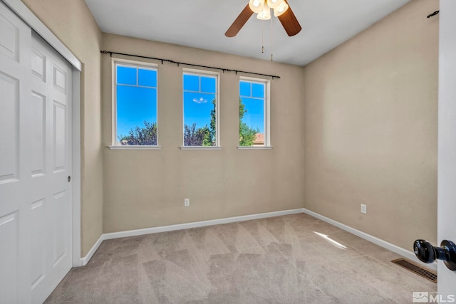 unfurnished bedroom featuring a closet, ceiling fan, and light colored carpet