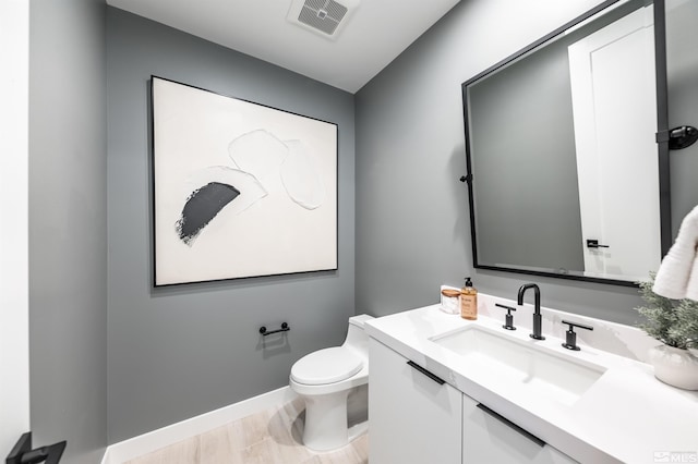 bathroom featuring toilet, vanity, and wood-type flooring