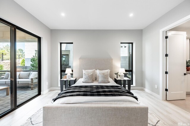 bedroom with multiple windows, access to outside, and light wood-type flooring