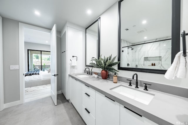 bathroom featuring double vanity and a shower with door