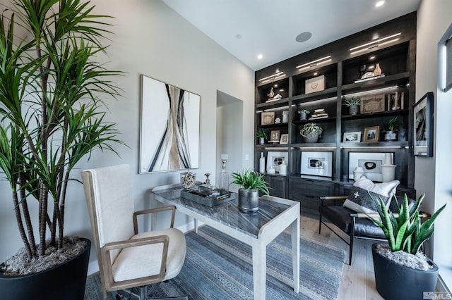 office area featuring built in shelves and wood finished floors