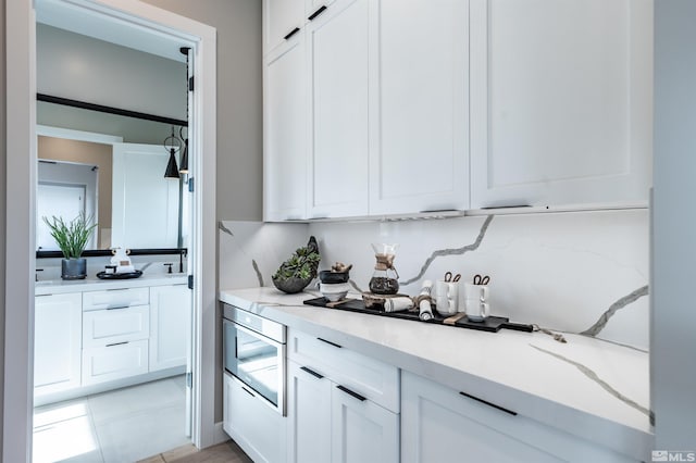 kitchen with light tile patterned floors and white cabinetry