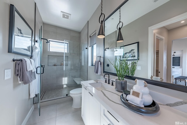 bathroom with tile patterned flooring, toilet, vanity, visible vents, and a stall shower