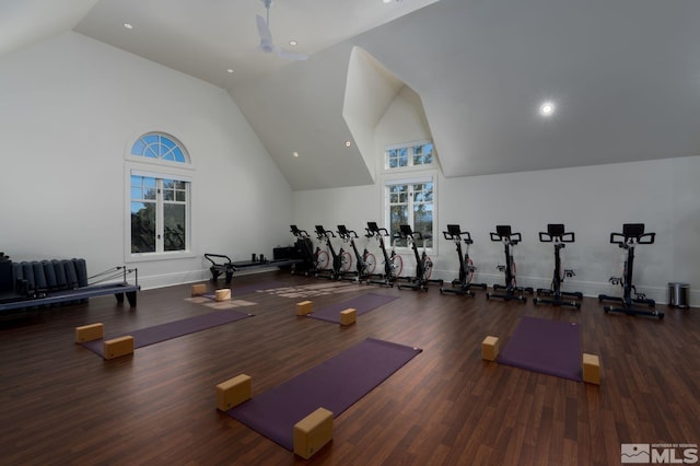 gym with high vaulted ceiling, dark wood finished floors, and baseboards