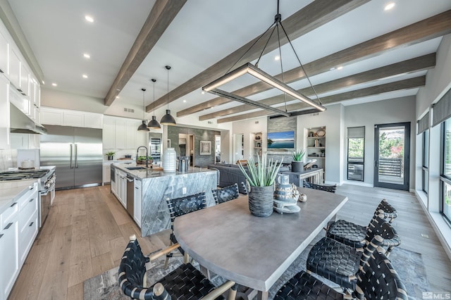 dining space featuring visible vents, beamed ceiling, light wood-type flooring, a fireplace, and recessed lighting