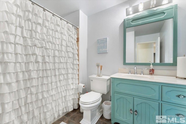 full bathroom with tile patterned flooring, curtained shower, vanity, and toilet