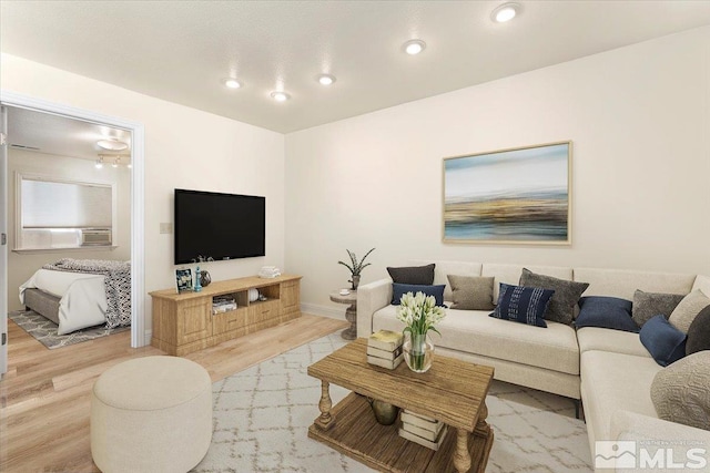 living area with baseboards, wood finished floors, and recessed lighting