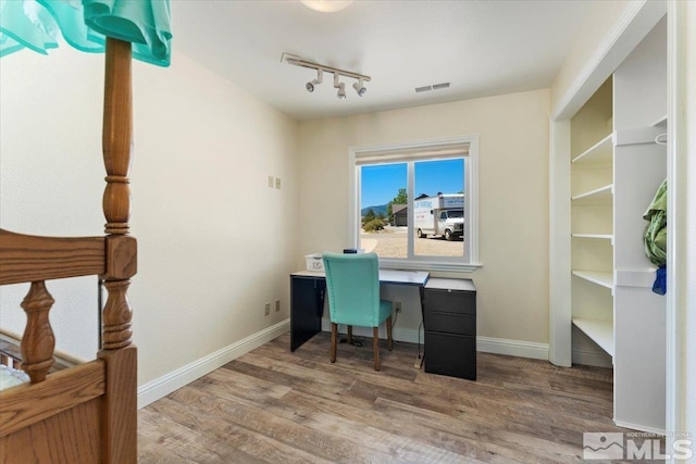 office area featuring track lighting, wood finished floors, visible vents, and baseboards