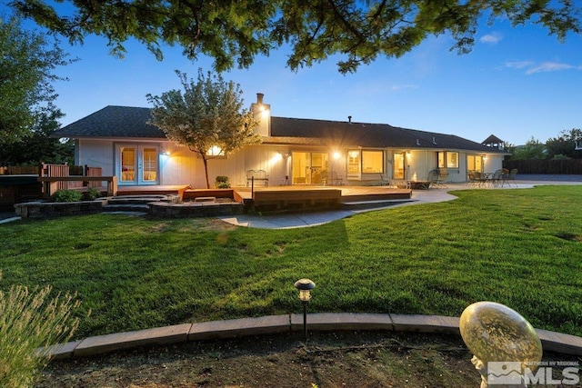 back of property with french doors, a patio area, and a yard