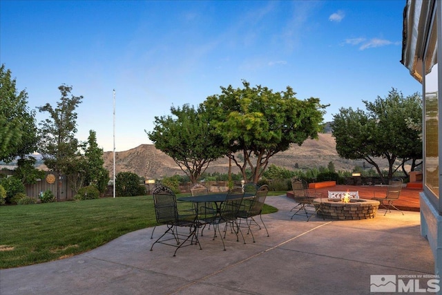 view of patio / terrace featuring a fire pit, outdoor dining space, and a mountain view