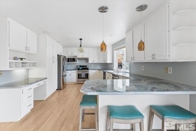 kitchen with open shelves, a peninsula, white cabinetry, and stainless steel appliances