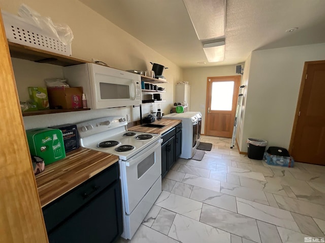 kitchen featuring wooden counters, white appliances, a textured ceiling, light tile patterned floors, and washer / dryer