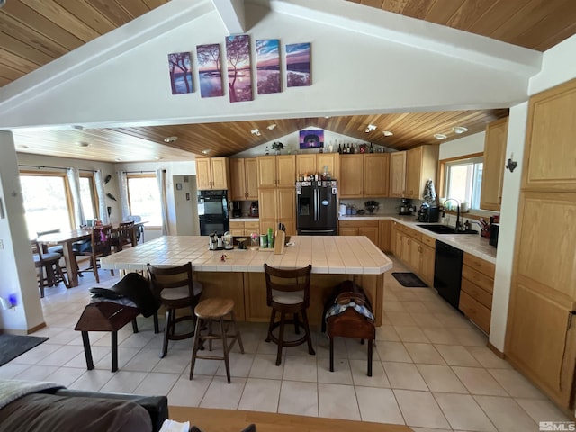 kitchen featuring a kitchen island, tile counters, wood ceiling, black appliances, and a sink