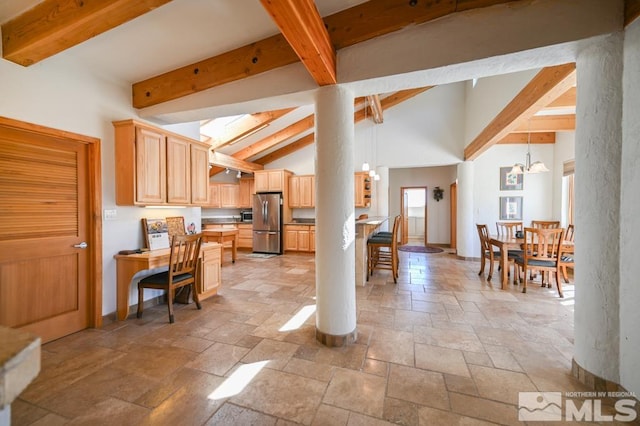 kitchen featuring light brown cabinets, stainless steel refrigerator, light tile patterned floors, an inviting chandelier, and lofted ceiling with beams