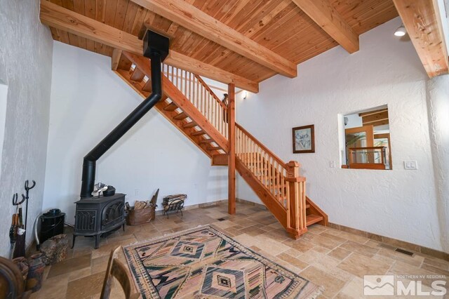 tiled living room with beam ceiling, wood ceiling, and a wood stove