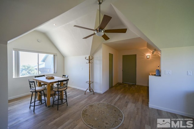 dining area featuring ceiling fan, vaulted ceiling, and wood-type flooring