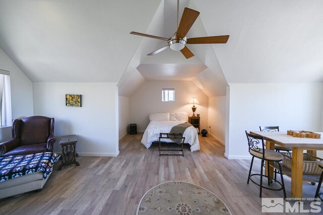 bedroom with ceiling fan, lofted ceiling, and wood-type flooring