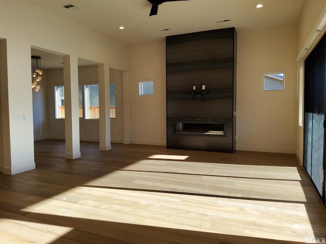 unfurnished living room featuring a notable chandelier and wood-type flooring