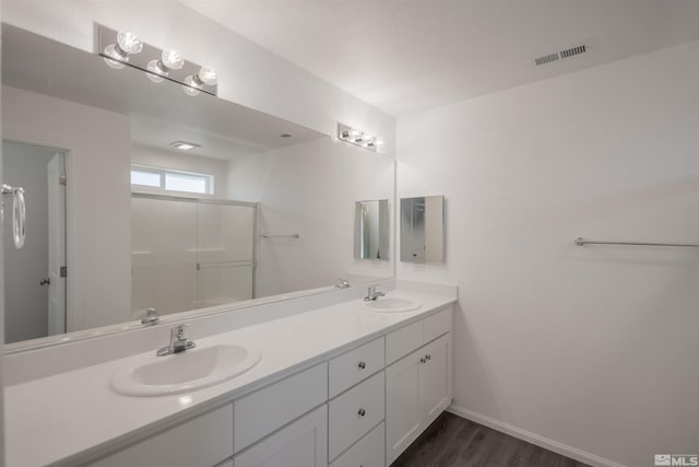 bathroom featuring vanity, hardwood / wood-style flooring, and a shower with door