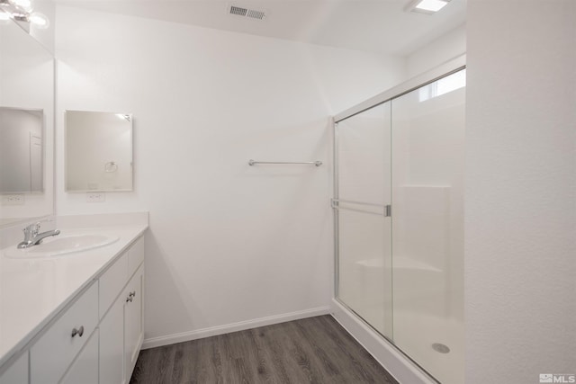 bathroom with vanity, hardwood / wood-style flooring, and a shower with door