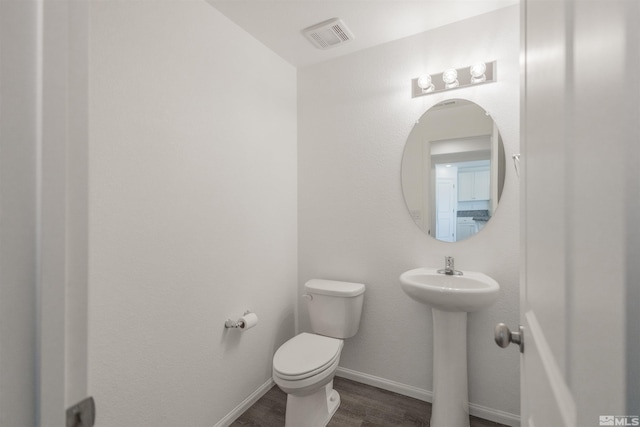 bathroom with toilet and hardwood / wood-style flooring