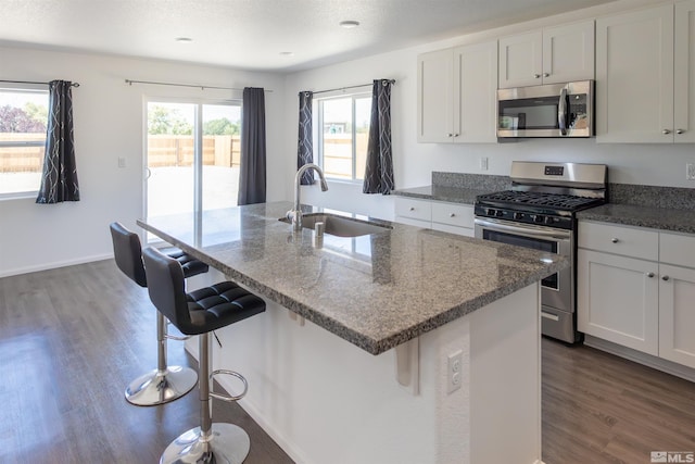 kitchen with white cabinets, sink, stainless steel appliances, and plenty of natural light