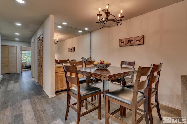 dining room with hardwood / wood-style floors and a chandelier