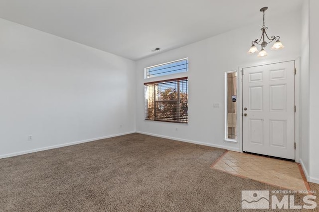 entryway featuring an inviting chandelier and light colored carpet