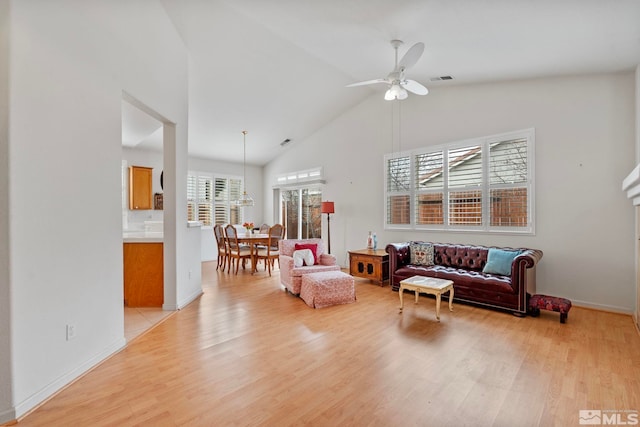 living room with visible vents, high vaulted ceiling, light wood-type flooring, and a ceiling fan