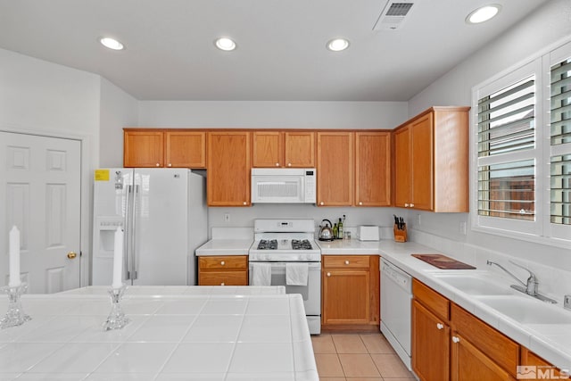 kitchen with white appliances, visible vents, tile countertops, a sink, and recessed lighting