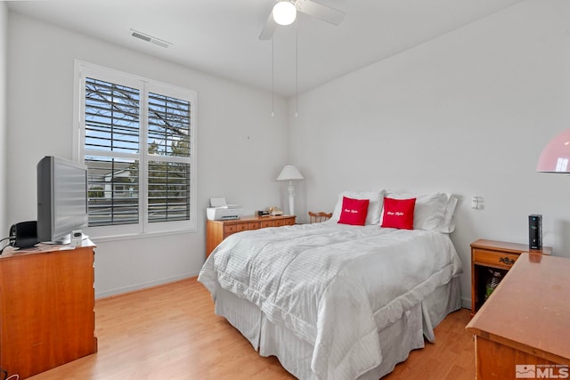 bedroom featuring light wood-style floors, baseboards, visible vents, and a ceiling fan