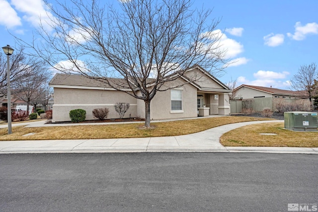 view of front of property with a front lawn, fence, and stucco siding