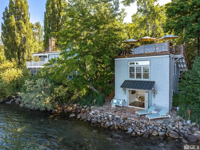 rear view of house featuring a patio and a water view