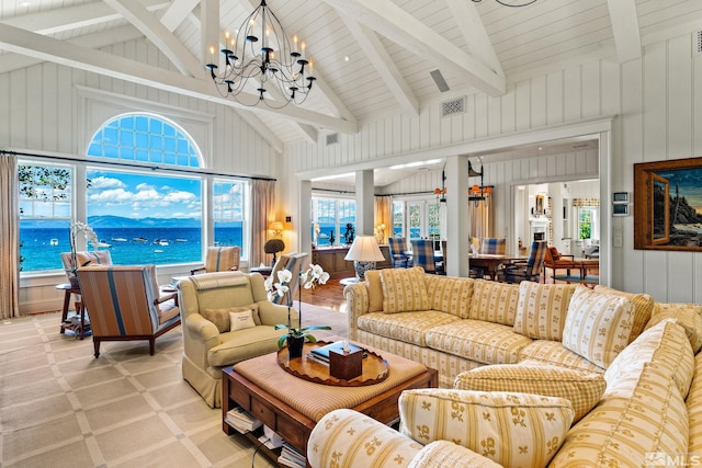 carpeted living room with beam ceiling, high vaulted ceiling, an inviting chandelier, and a water view