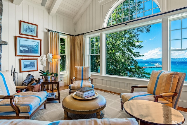 sunroom featuring vaulted ceiling with beams and a water view