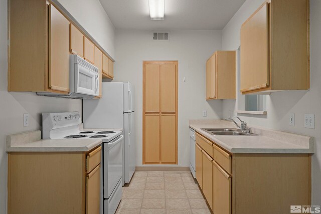 kitchen with sink, white appliances, light tile patterned flooring, and light brown cabinets