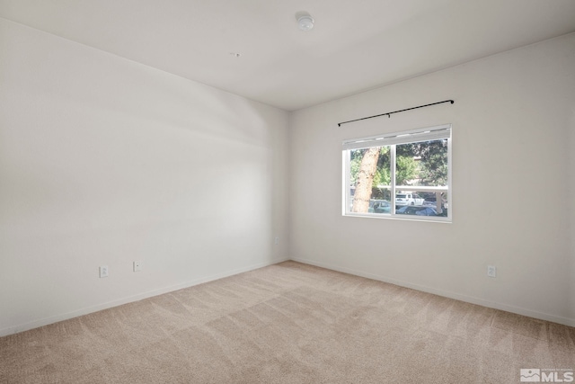 unfurnished room featuring light carpet