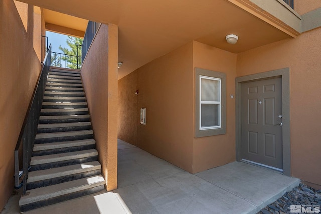 entrance to property with a patio and stucco siding