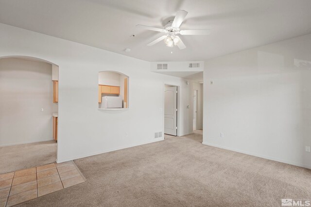 empty room with ceiling fan and light carpet