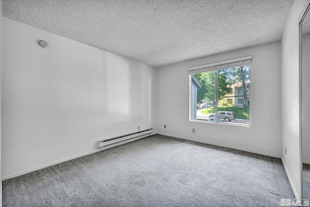 empty room with carpet, baseboards, a textured ceiling, and baseboard heating